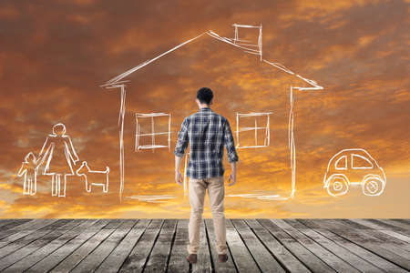 Asian man look toward the drawing house and family in the heaven.の写真素材