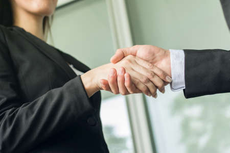 Asian business woman hold a man's hand, concept of teamwork.の写真素材