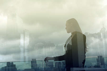 Silhouette of businesswoman stand and look far away in Hong Kong, Asia. Double exposure.の写真素材