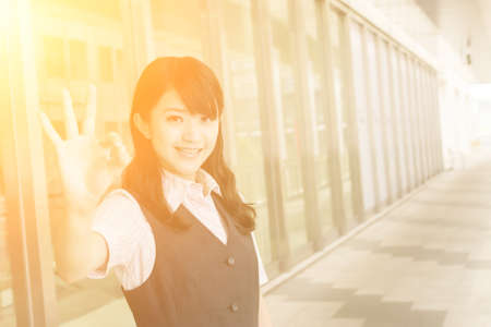 Business woman give you an Ok sign, closeup portrait in outside of modern city.の写真素材