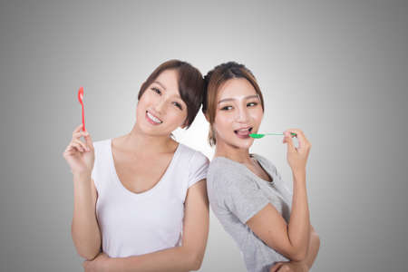 Asian woman with her friend play with spoon.の写真素材