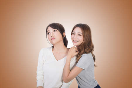 Asian woman with her friend, studio shot portrait.の写真素材