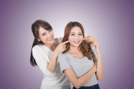 Asian woman with her friend, studio shot portrait.の写真素材