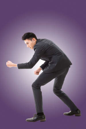 Digging pose or using shovel, full length portrait of Asian young business man.の写真素材