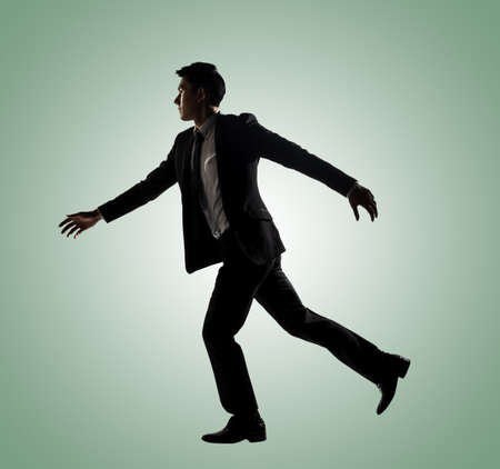 Confident businessman running, silhouette portrait isolatedの写真素材