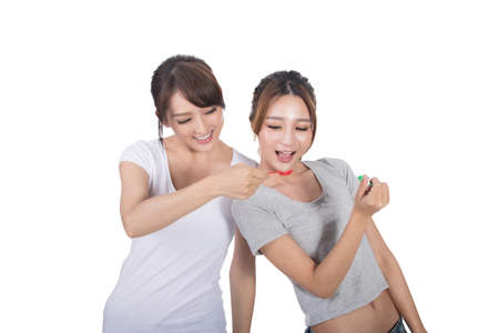 Asian woman with her friend play with spoon.の写真素材