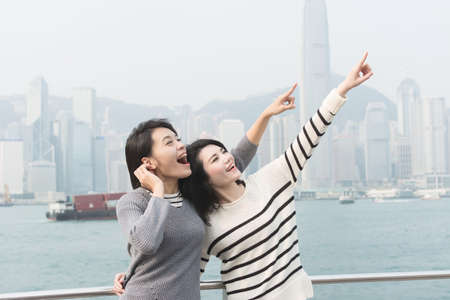 Asian happy young girls traveling at Victoria harbor, Hong Kong, Asia.の写真素材