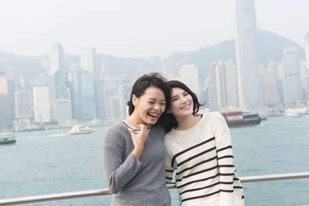 Asian happy young girls traveling at Victoria harbor, Hong Kong, Asia.の写真素材