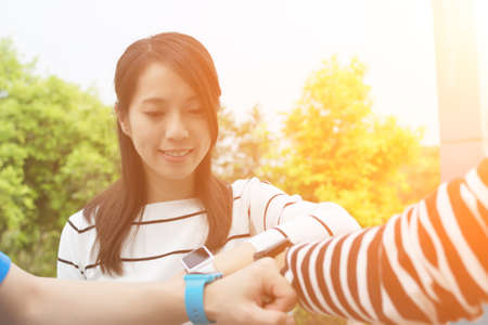 Group of friends using smart watch togetherの写真素材