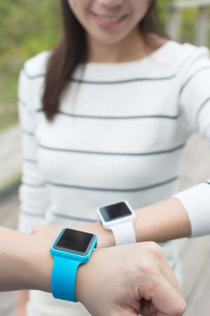 Group of friends using smart watch togetherの写真素材