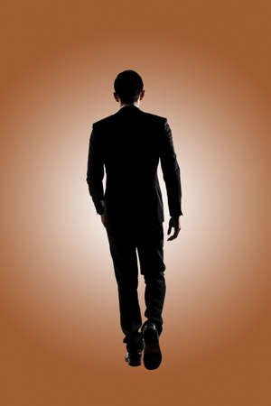 Confident businessman walking, silhouette portrait isolatedの写真素材