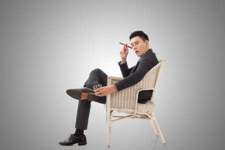 Cunning businessman of Asian sit on chair.の写真素材