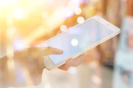 using smartphone in a market or department store, closeup image. double exposure