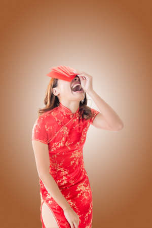 Attractive Chinese woman dress traditional cheongsam and hold red envelopeの写真素材