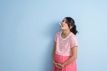 unhealthy Asian pregnant woman smoking