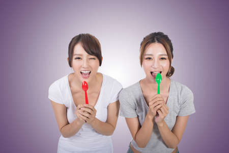 Asian woman with her friend play with spoon.の写真素材
