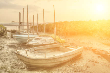 Abandoned boats in port in sunset city.の写真素材