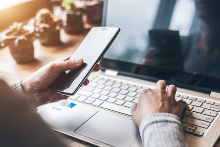 concept of working at home with laptop on table and using cellphone