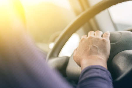 woman driving a car with hands on horn buttonの写真素材