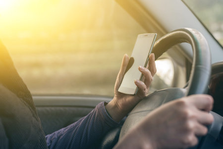 women driver with a cell phone in hand while driving