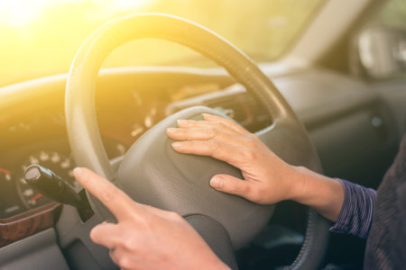 woman driving a car with hands on horn button