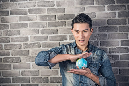 Asian young man hold a globe ball