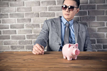 greedy businessman look at the pink pig bankの写真素材