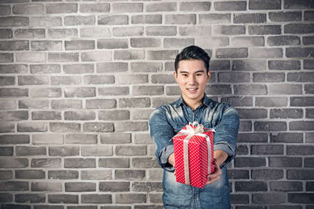 Asian young man hold a gift boxの写真素材