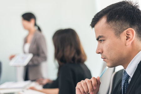 young business man thinking something at meetingの写真素材