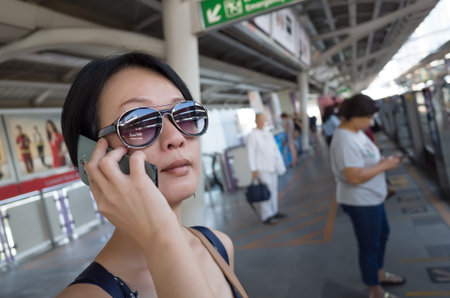asian woman talk on phone at station