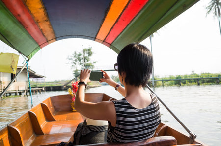 asian woman visiting the Floating Market in Bangkok on a boat tour