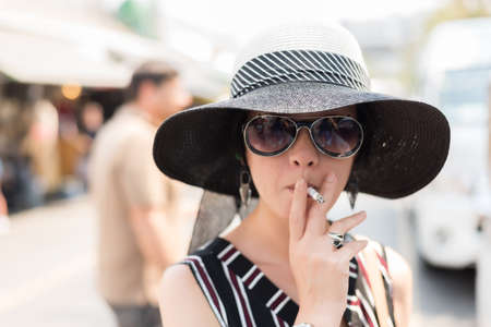 woman smoking at the market at streetの写真素材