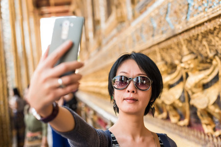 asian woman selfie at the temple of Grand Palace, Bangkok, Asiaの写真素材