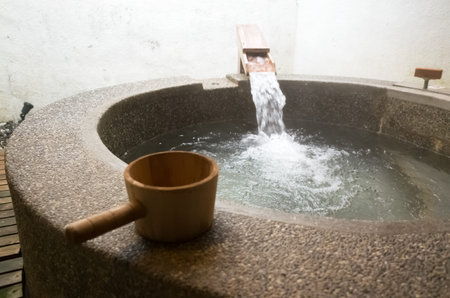 hot spring of stone pool with wooden ladle