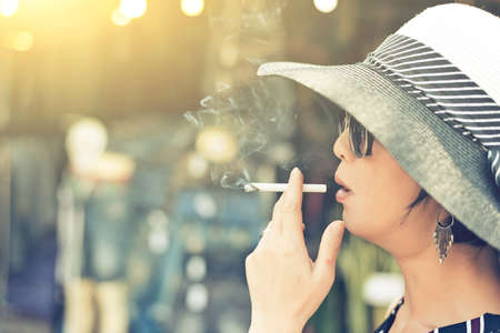 woman smoking at the market at streetの写真素材