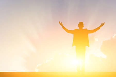 businessman standing against sunset with copyspace on skyの写真素材