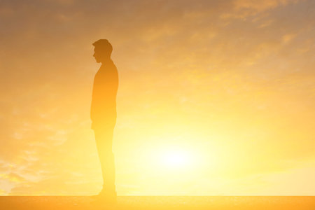 businessman standing against sunset with copyspace on sky