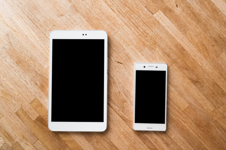 smartphone and tablet on wooden desk with nobodyの写真素材