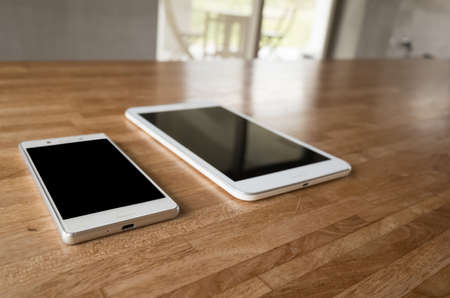 smartphone and tablet on wooden desk with nobodyの写真素材