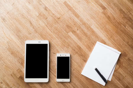 smartphone and tablet on wooden desk with nobodyの写真素材