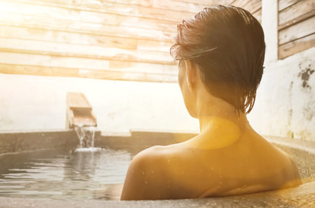 rear view of asian mature woman at the hot spring pool