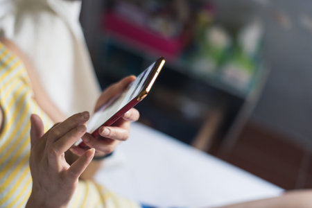 woman using smartphone on bed at home