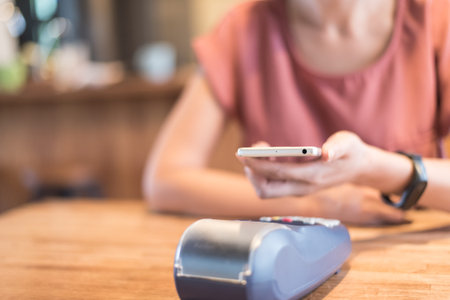 woman paying with NFC technology by a smartphone