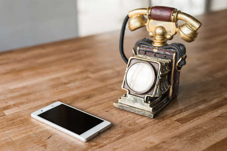 new and old telephone on the wooden deskの写真素材