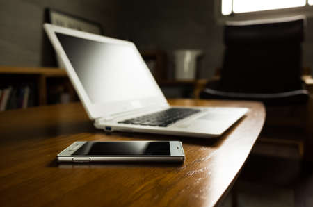 laptop and smartphone on the table with nobody, concept of working at homeの写真素材