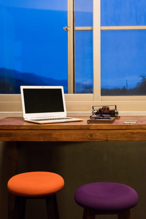 working at home with laptop on the wooden table in the night