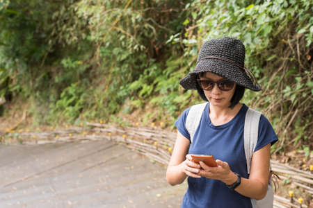 woman using cellphone when hiking at outdoorの写真素材