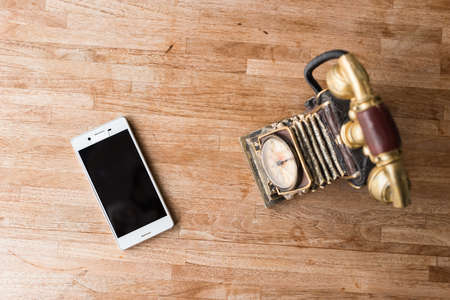 new and old telephone on the wooden deskの写真素材