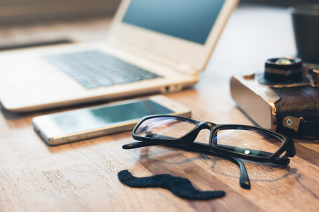 moustache and glasses with laptop on table