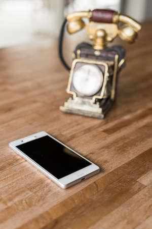new and old telephone on the wooden deskの写真素材